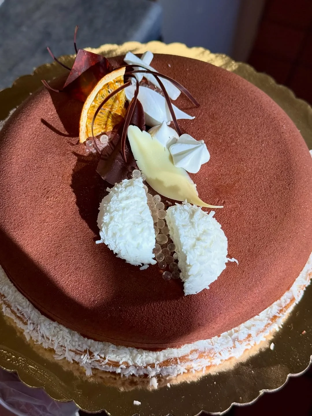 Cocoa-Velvet & Coconut entremet — matte cocoa velvet tier with shaved coconut and dried citrus